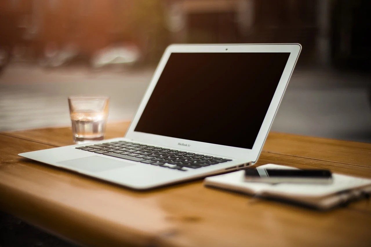 Laptop auf einem Tisch, Glas, Notizblock